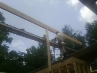 Carpenter setting a ridge beam over a new addition frame — Ice Dam Removal by Roofing Brothers in Jersey