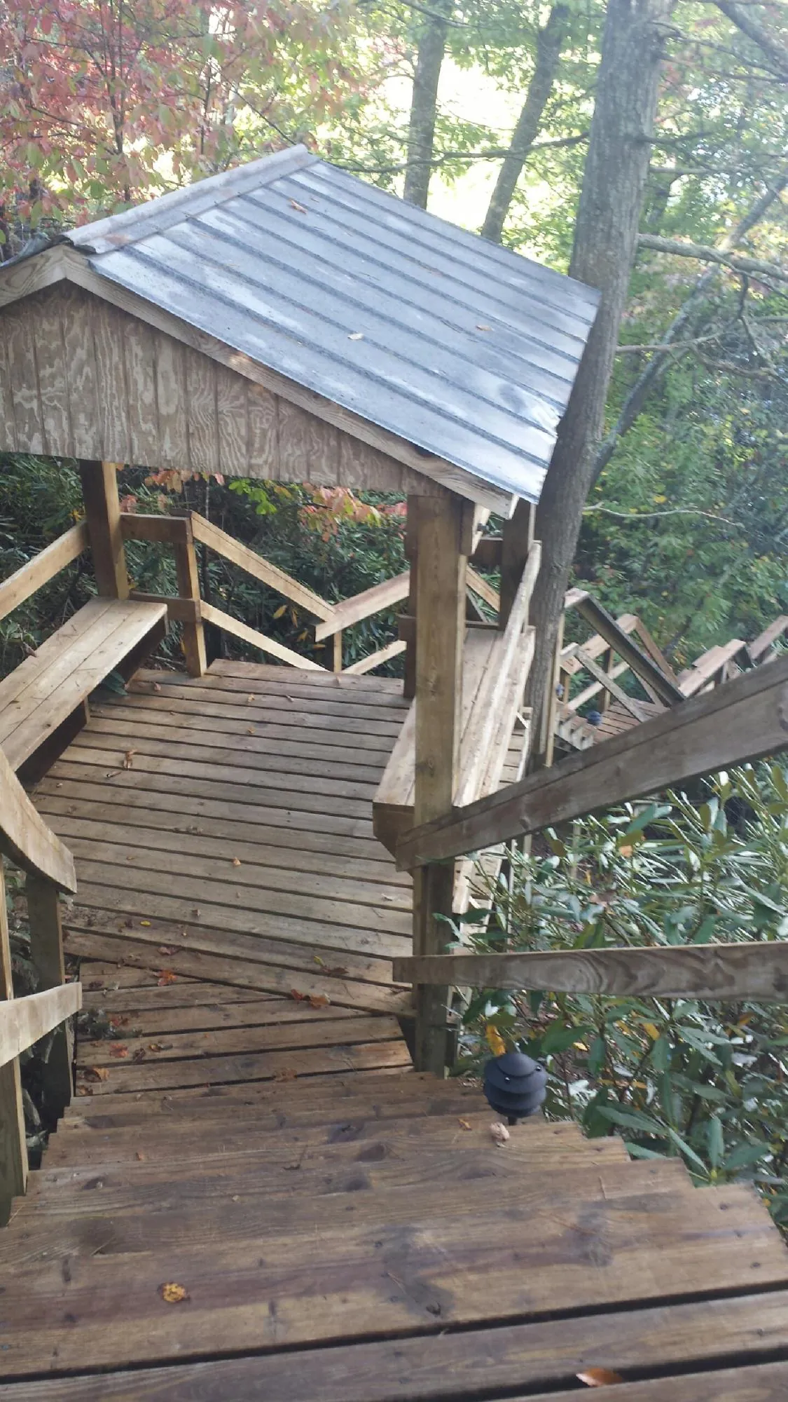 Metal roofed shelter over wooden steps on a wooded walkway — Skylight Repair & Installation work by our crew in Jersey