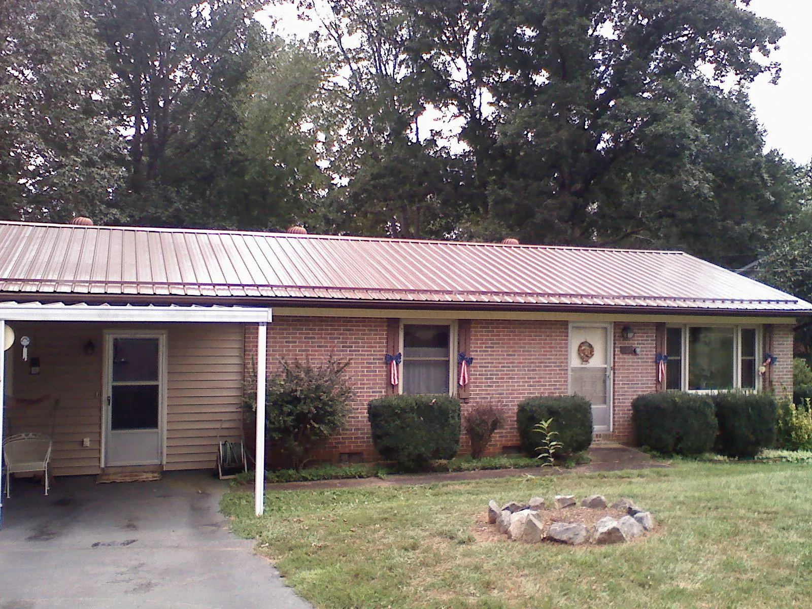 Bronze metal roof and carport on a brick ranch home — Roof Repair work by our crew in Jersey